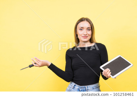 Service center. Laptop Repair. Female screwdriver unscrews laptop bolts on yellow background Service center. Laptop Repair. Female screwdriver unscrews laptop bolts on yellow background 101258461