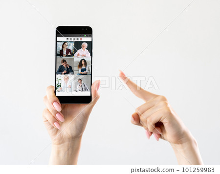 Mobile e-learning. Video conference. Remote education. Hand pointing at group studying online on smartphone screen on white empty space. 101259983