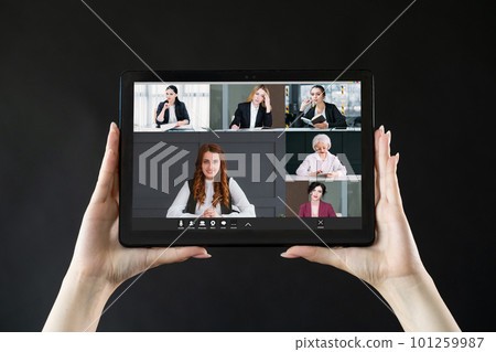 Video call. Business meeting. Distant cooperation. Professional female team brainstorming working online on tablet screen in hands on black. 101259987