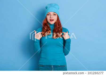 Amazing beautiful lady indicates at her self, wearing casual blue shirt isolated over blue background, wears red lips, keeps mouth opened, looks at camera with excitement look. 101260277