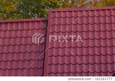 House with new brown metal tile roof and rain gutter. Metallic Guttering System, Guttering and Drainage Pipe Exterior 101261777