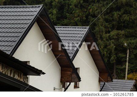 House with new brown metal tile roof and rain gutter. Metallic Guttering System, Guttering and Drainage Pipe Exterior 101261785
