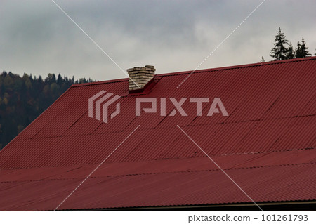 Red house roof with red brick chimney. Ceramic chimney, metal roof tiles, gutters 101261793