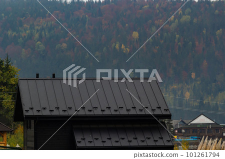 House with new brown metal tile roof and rain gutter. Metallic Guttering System, Guttering and Drainage Pipe Exterior House with new brown metal tile roof and rain gutter. Metallic Guttering System, Guttering and Drainage Pipe Exterior 101261794