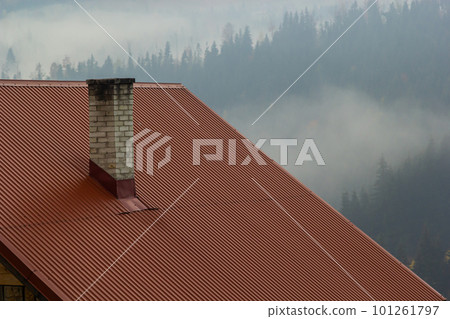 Roof of a new home. Ceramic chimney, metal roof tiles, gutters, roof window. Single family house Roof of a new home. Ceramic chimney, metal roof tiles, gutters, roof window. Single family house 101261797