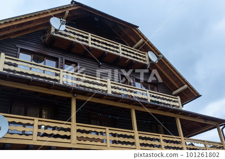 House with new brown metal tile roof and rain gutter. Metallic Guttering System, Guttering and Drainage Pipe Exterior 101261802