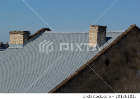 Roof of a new home. Ceramic chimney, metal roof tiles, gutters, roof window. Single family house Roof of a new home. Ceramic chimney, metal roof tiles, gutters, roof window. Single family house 101261835