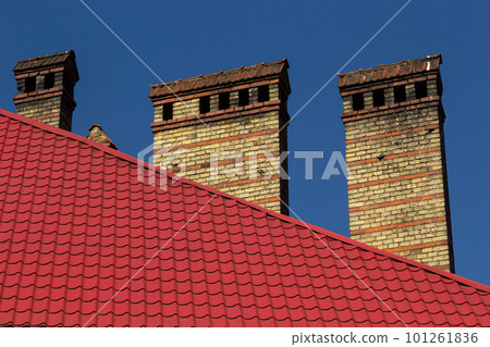Red house roof with red brick chimney. Ceramic chimney, metal roof tiles, gutters Red house roof with red brick chimney. Ceramic chimney, metal roof tiles, gutters 101261836