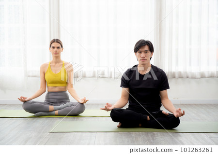 Young man and woman practicing yoga and meditating for relaxation. Young man and woman practicing yoga and meditating for relaxation. 101263261