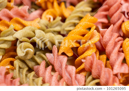 Rice vegetable pasta in the form of spirals, top view. Healthy rice pasta with tomatoes, selenera, carrots and beets 101265095