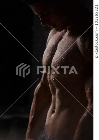 Athlete bodybuilder trains in the studio in the rain. Athlete bodybuilder trains in the studio in the rain. 101265821