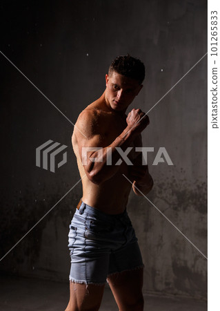 Athlete bodybuilder trains in the studio in the rain. Athlete bodybuilder trains in the studio in the rain. 101265833