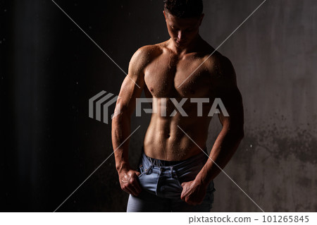 Athlete bodybuilder trains in the studio in the rain. Athlete bodybuilder trains in the studio in the rain. 101265845