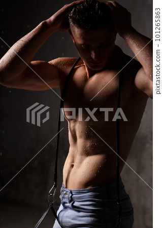 Athlete bodybuilder trains in the studio in the rain. 101265863