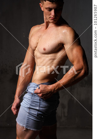 Athlete bodybuilder trains in the studio in the rain. 101265987