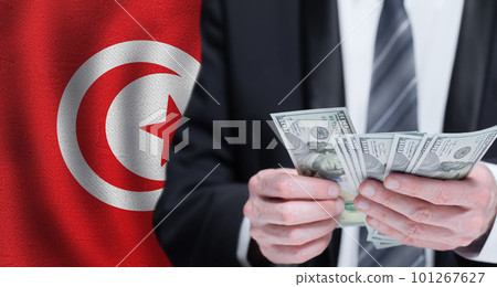 Hands holding dollar money on flag of Tunisia 101267627