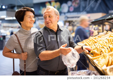 couple chooses sweet puffs in bakery couple chooses sweet puffs in bakery 101268234