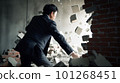 Businessman in a suit breaking the wall 101268451