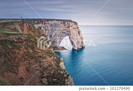 Sightseeing view to the Porte d'Aval natural arch cliff washed by Atlantic ocean waters at Etretat, Normandy, France. Beautiful coastline scenery with famous Falaise d'Aval 101270490