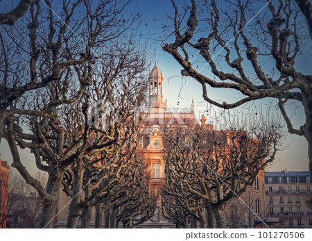 City Hall of Asnieres as seen through the leafless sycamore trees alley outdoors in the park. Asnieres-sur-Seine mairie backyard facade view in sunset light, northwestern suburb of Paris, France City Hall of Asnieres as seen through the leafless sycamore trees alley outdoors in the park. Asnieres-sur-Seine mairie backyard facade view in sunset light, northwestern suburb of Paris, France 101270506