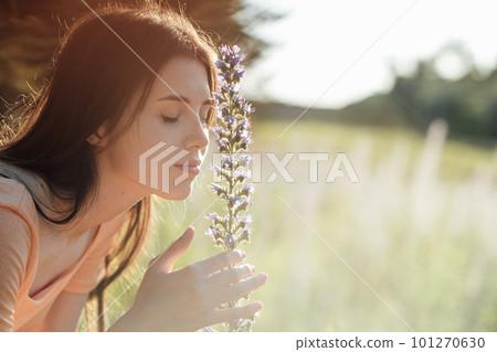 Celebrate Earth Month, Earth Day. Spend time in nature. Connect to nature is way to mitigate climate anxiety. Young woman, girl walks outdoors and enjoys nature 101270630