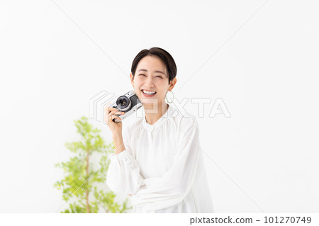 Smiling woman holding a film camera Smiling woman holding a film camera 101270749