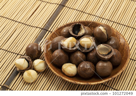 竹蓆上木盤中帶殼的澳洲堅果 101272049