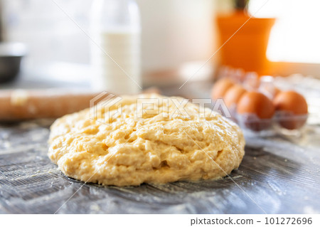 Fresh raw dough on a floured wooden surface and ingredients for making dough Fresh raw dough on a floured wooden surface and ingredients for making dough 101272696