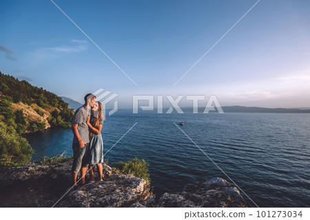 Romantic Couple in Hugs Enjoying Sunrise on Lake 101273034