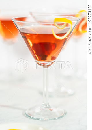 Cosmopolitan cocktail in a martini glass and decorated with a lemon swirl. 101273165