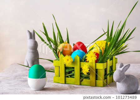 Easter spring decoration with painted eggs, rabbits, field flowers, wooden box and wheatgrass Easter spring decoration with painted eggs, rabbits, field flowers, wooden box and wheatgrass 101273489