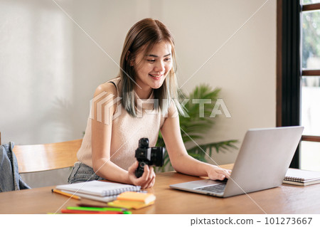 Female fashion artist holding camera and checking photo of new f Female fashion artist holding camera and checking photo of new f 101273667