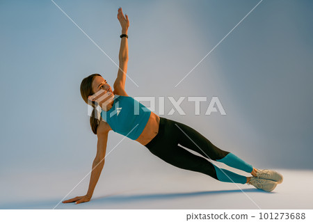 Healthy sporty woman doing side plank exercises on studio background. Healthy Lifestyle Concept Healthy sporty woman doing side plank exercises on studio background. Healthy Lifestyle Concept 101273688