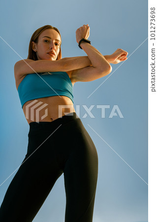 Attractive woman doing warm up hands exercises and stretching her body preparing to gym in studio Attractive woman doing warm up hands exercises and stretching her body preparing to gym in studio 101273698
