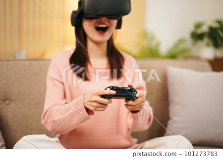 Young woman lesbian wearing sweater and VR goggles while holding Young woman lesbian wearing sweater and VR goggles while holding 101273783