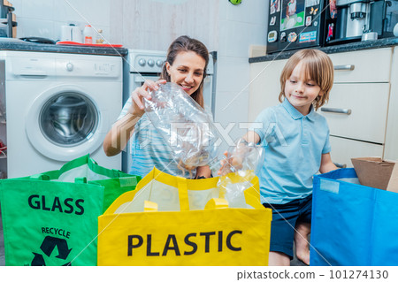 Mother is teaching kid how to recycle help the boy aware environmental importance - mom educates son sort garbage into different bins on kitchen. Family sorting garbage at home. Concept of recycling Mother is teaching kid how to recycle help the boy aware environmental importance - mom educates son sort garbage into different bins on kitchen. Family sorting garbage at home. Concept of recycling 101274130