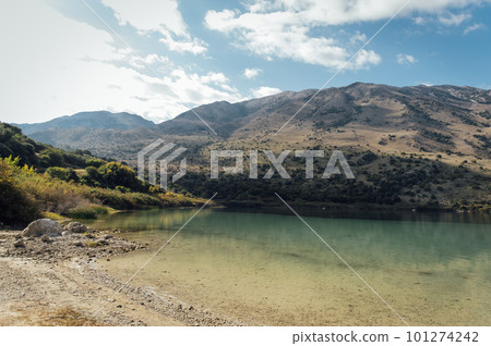 Kournas Mountain Lake in Greece. Cozy summer day and calm water in the lake Kournas Mountain Lake in Greece. Cozy summer day and calm water in the lake 101274242