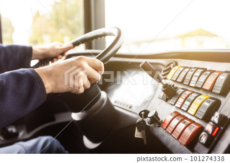 Hands of the driver in a modern bus according to the ride, detail of the bus drivers steering wheel and driving a passenger bus, transportation concept 101274338