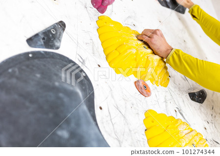 Young climber climbing on the boulder wall indoor, rear view, concept of extreme sports and bouldering 101274344