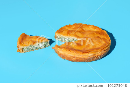 Phyllo dough savory pie with spinach and cheese, isolated on a blue background 101275048