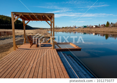 A dock with a picnic table and a bench on it A dock with a picnic table and a bench on it 101275077
