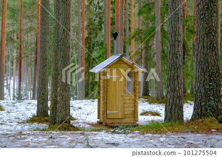 Wooden outdoor toilet in the forest with an open door. 101275504