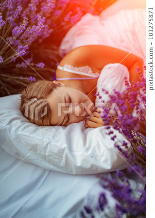 A middle-aged woman lies in a lavender field and enjoys aromatherapy. Aromatherapy concept, lavender oil, photo session in lavender A middle-aged woman lies in a lavender field and enjoys aromatherapy. Aromatherapy concept, lavender oil, photo session in lavender 101275871