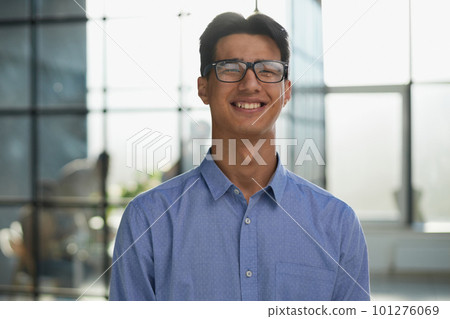 Close-up of smiling asian businessman standing in modern office 101276069