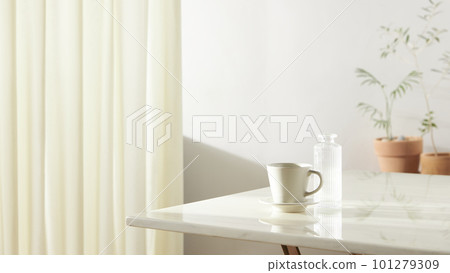 A room with a calm atmosphere, with clay pots placed in front of the wall and curtains letting in natural light. Glass bottles, coffee, and various objects on a marble table 101279309