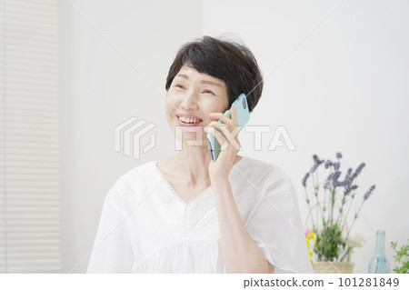 中年婦女在家裡用智能手機打電話 101281849