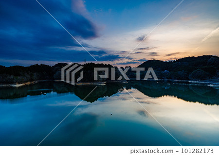 Flowing clouds and mirror-like water surface by long-second exposure (the sun setting on the mountainside) ➄ Spring 2023 at Nunome Dam in Nara Flowing clouds and mirror-like water surface by long-second exposure (the sun setting on the mountainside) ➄ Spring 2023 at Nunome Dam in Nara 101282173