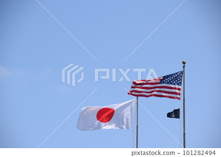 Japanese and American flags fluttering in the blue sky Japanese and American flags fluttering in the blue sky 101282494
