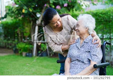 Caregiver help Asian elderly woman disability patient sitting on wheelchair in park, medical concept. 101282795