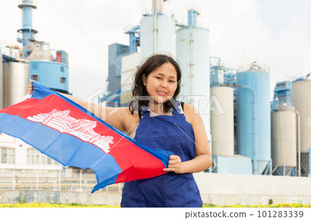 Happy young woman with flag of Cambodia against background of factory Happy young woman with flag of Cambodia against background of factory 101283339